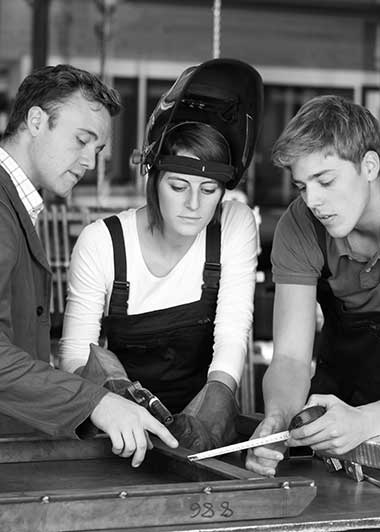 3 junge Menschen in Werkstatt als Symbol für Ausbildung